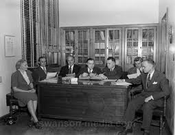 Seven people gathered around a desk