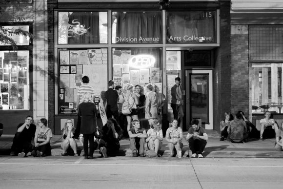 Crowd gathers on the curb outside 115 Division Avenue