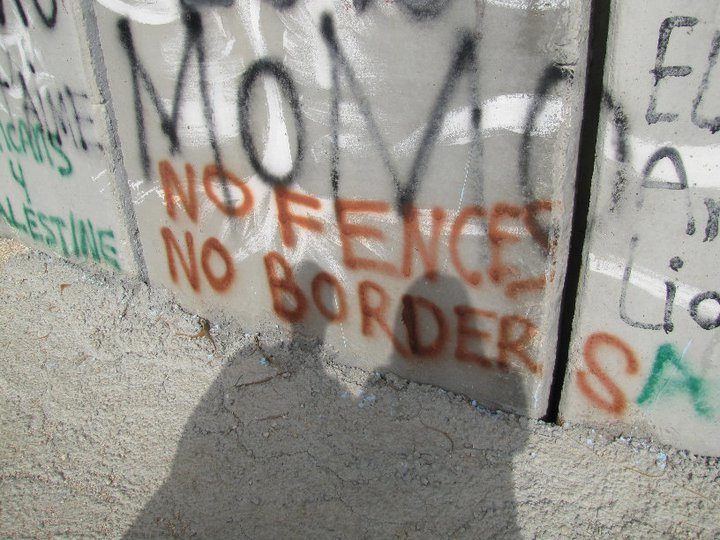 Spray paint on a concrete wall: No Fences No Borders