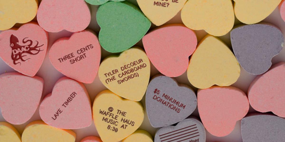 Candy conversation hearts with concert details printed on the backs