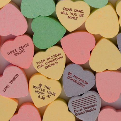 Candy conversation hearts with concert details printed on the backs