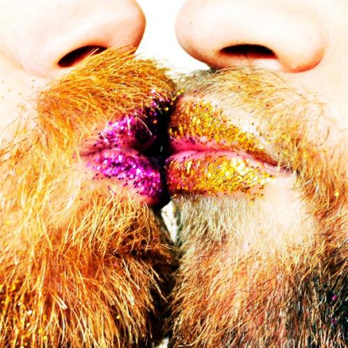 Two bearded men kissing wearing glitter lipstick. Text reads Dangerous Ponies.