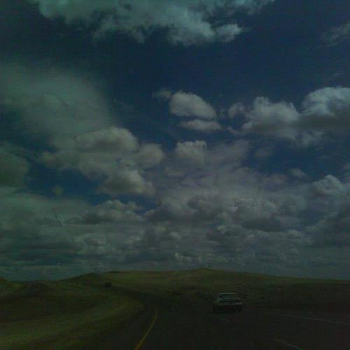 Dark photograph of a car driving on an open road